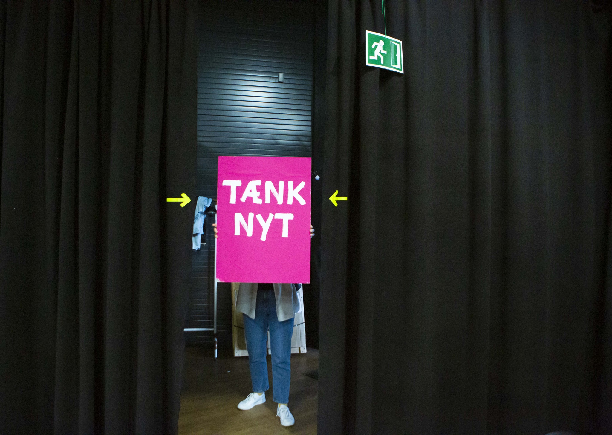 Tænk nyt-skilt ved et scenetæppe