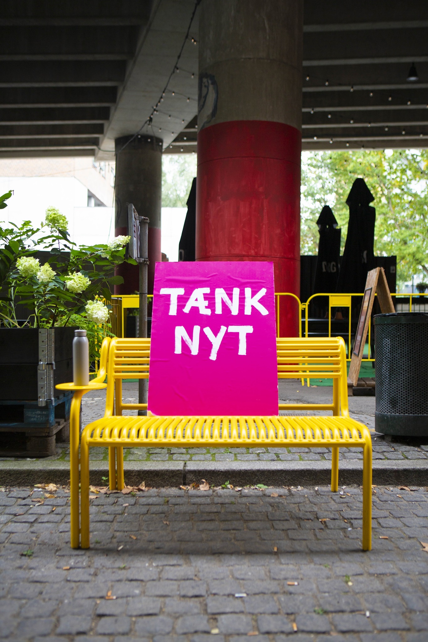Tænk nyt-plakaten slapper af på en gul bænk