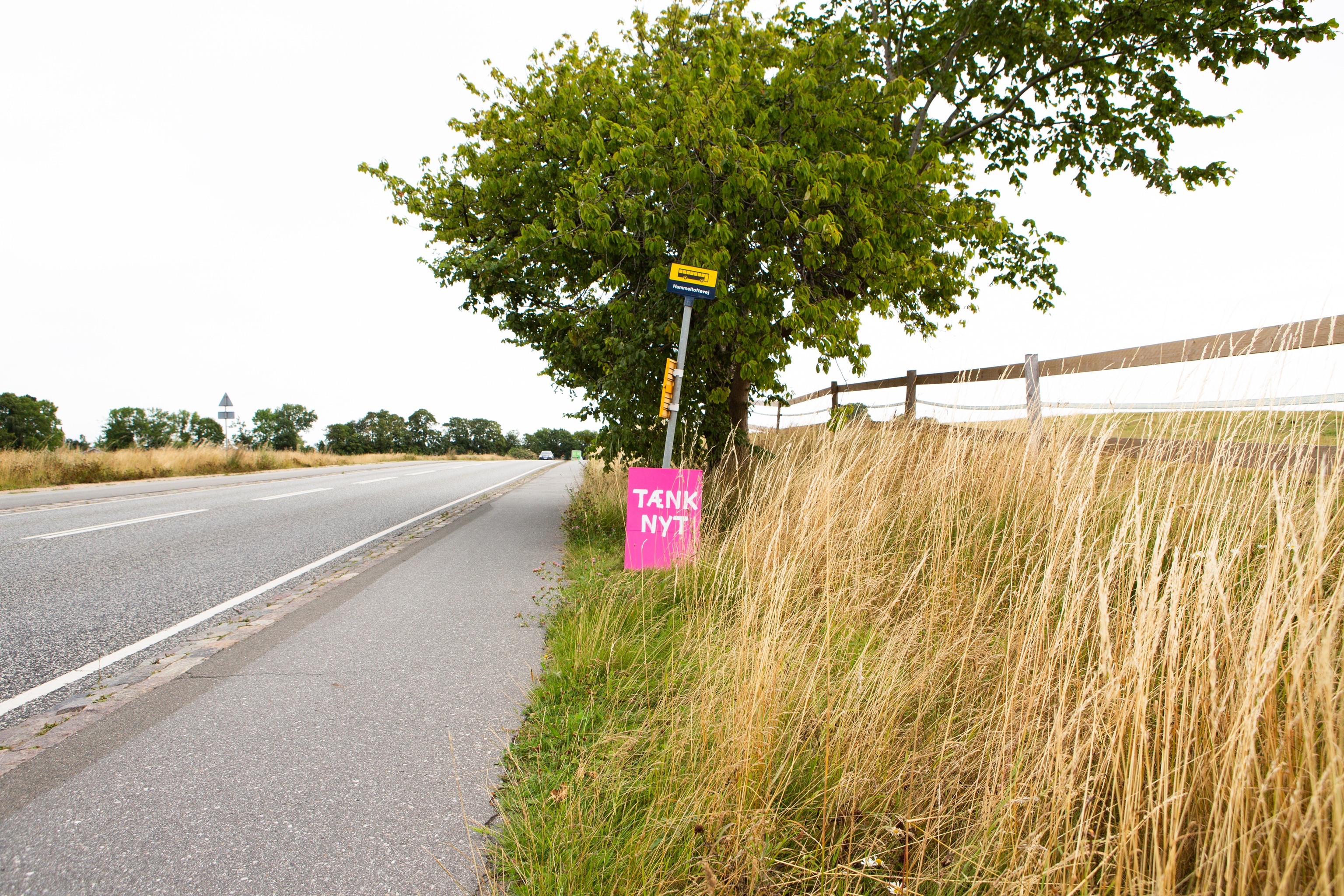 Tænk nyt-skilt ved et øde busstoppested
