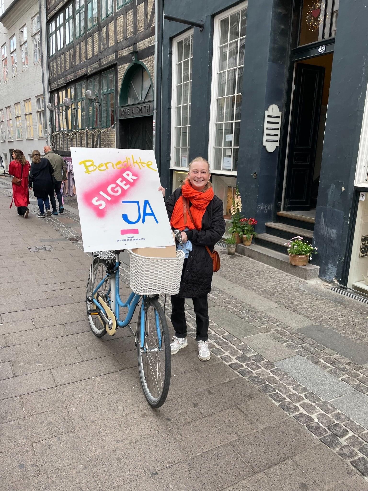 Ung kvinde med en cykel og en JA-plakat