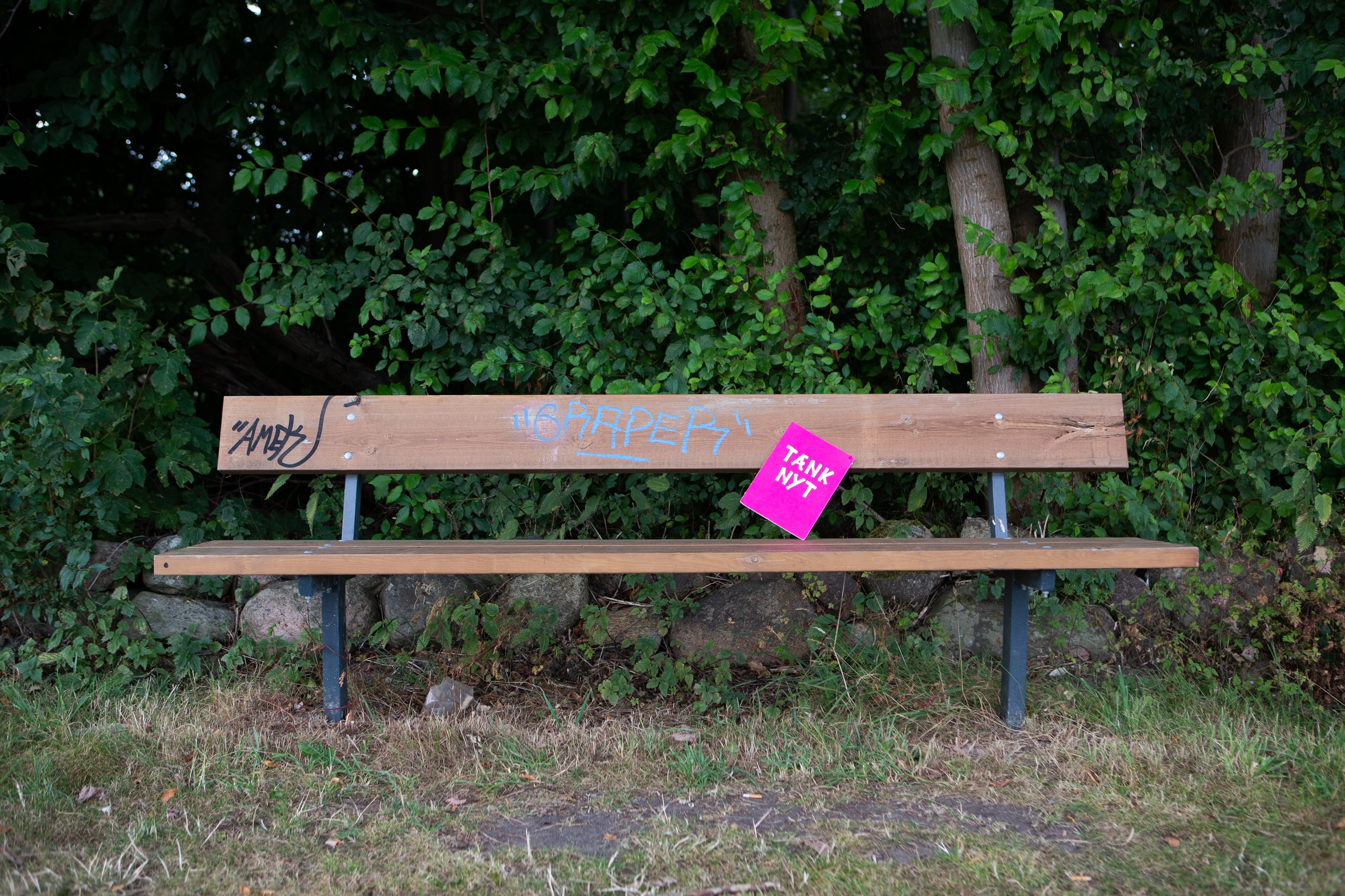 Tænk nyt-skilt sidder på en bænk