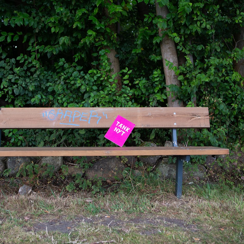 Tænk nyt-skilt sidder på en bænk