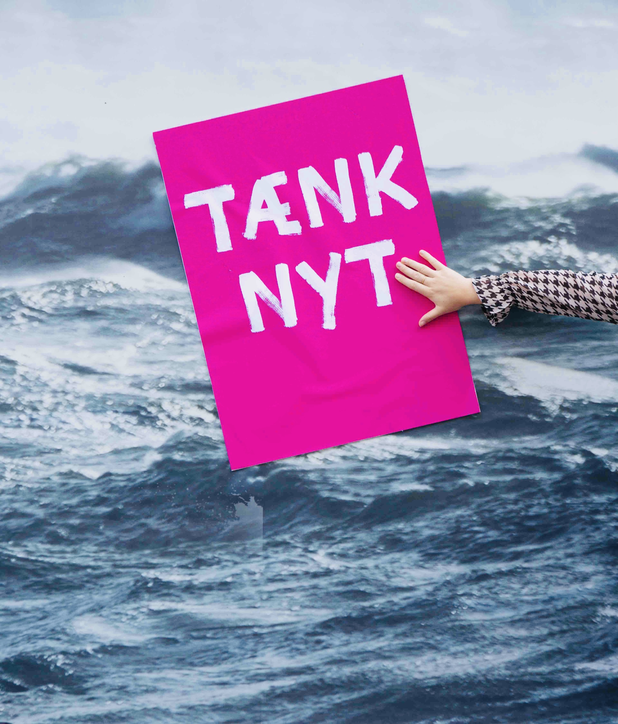 Tænk nyt-skilt ved et billede af havet