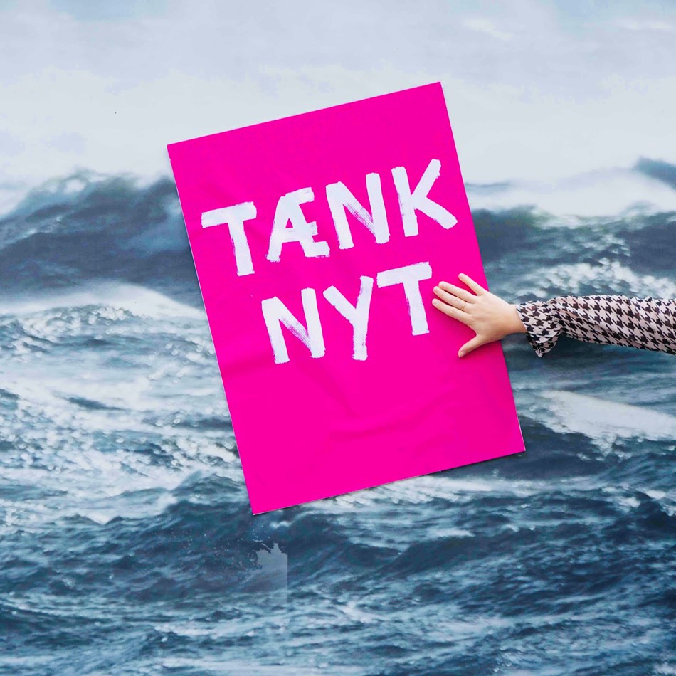 Tænk nyt-skilt ved et billede af havet