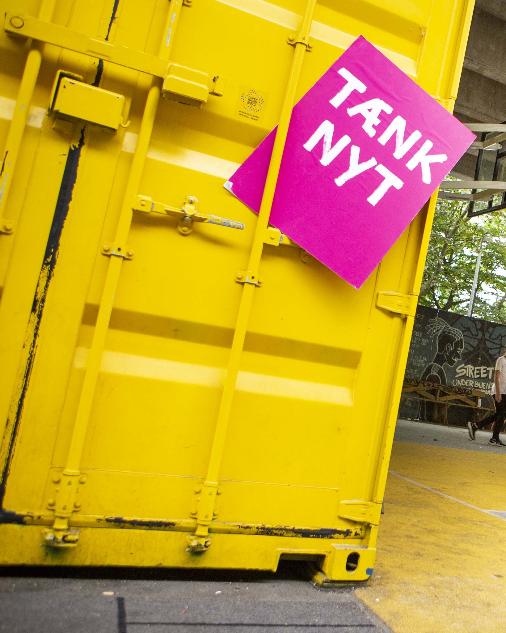 Tænk nyt-skilt foran en gul container